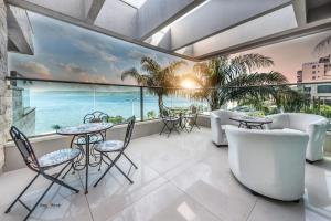 a balcony with tables and chairs and a view of the ocean at the royal lake views in Tiberias