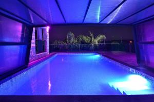 a swimming pool in a house with purple lights at the royal lake views in Tiberias
