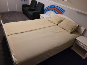 a large bed in a room with a chair at Fargerik retro enebolig,parkering på stedet! in Trondheim