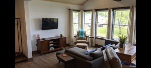 a living room with a couch and a tv at Whitney Bay House on CHQ Lake in Mayville