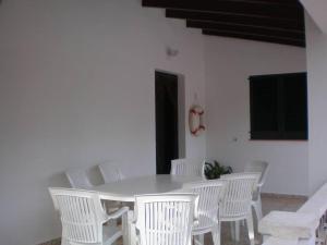een witte tafel en witte stoelen in een kamer bij Villa en Sa Roca in Es Mercadal