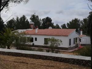 een wit huis met een rood dak bij Villa en Sa Roca in Es Mercadal
