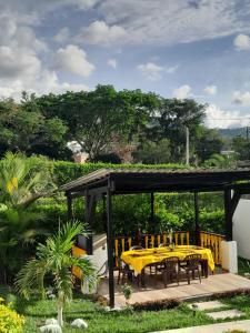 a patio with a yellow table and chairs at Casa El Limonar Garzón Hospedaje Campestre in Garzón