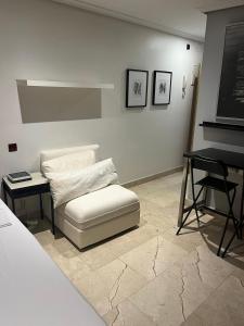 ein Wohnzimmer mit einer weißen Couch und einem Klavier in der Unterkunft Exyca Malasaña in Madrid