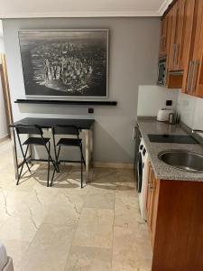 eine Küche mit einem Tisch mit Stühlen und einem Bild an der Wand in der Unterkunft Exyca Malasaña in Madrid