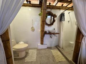 y baño con aseo y lavamanos. en Bella Flor Hostel Palomino, en Palomino