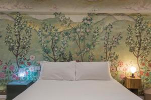 1 dormitorio con 1 cama y papel pintado con motivos florales en Moscova Luxury B&B, en Milán