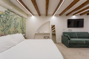 una camera con un letto bianco e un divano verde di Moscova Luxury B&B a Milano