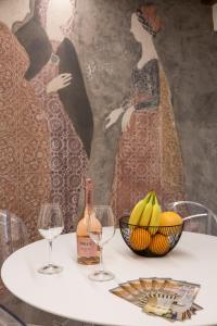 a table with two glasses of wine and a bowl of bananas at Moscova Luxury B&B in Milan