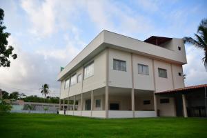 圣阿马鲁Casa das Dunas Residence até 8 pessoas (apto 3)的一座白色的大建筑,设有绿色草坪