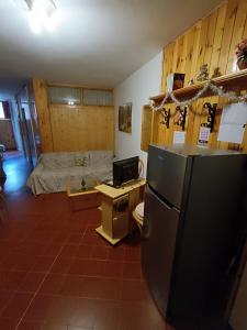 a room with a refrigerator and a bed at Le Marmotte - Appartamento in Abetone
