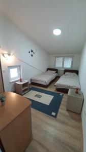 a small room with two beds and a desk at Kopaonik Apartman Aleksandar in Kopaonik