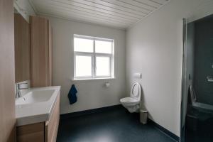 a bathroom with a sink and a toilet and a window at Spacious City Center Home by the Sea in Klaksvík