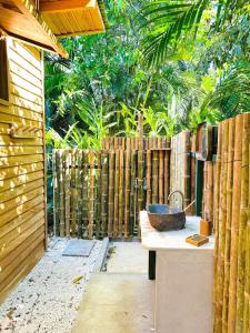 ein Badezimmer mit einem Waschbecken und einem Holzzaun in der Unterkunft Calamocha Lodge in Playa Santa Teresa