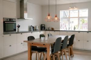 kuchnia z drewnianym stołem i krzesłami w obiekcie Spacious City Center Home by the Sea w mieście Klaksvík
