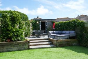 a garden with a blue couch and chairs on a patio at Baggies No.2 in Brighton & Hove