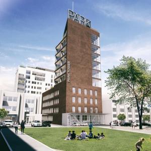 a group of people sitting in the grass in front of a building at Park Tower apartment v centru Zlína in Zlín