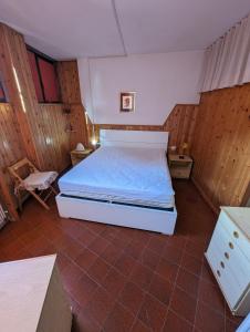 a bedroom with a bed in a room with wooden walls at Le Marmotte - Appartamento in Abetone