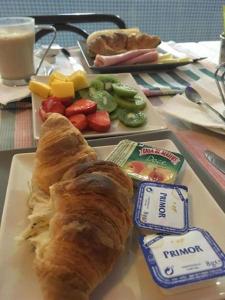 a plate of food with a loaf of bread and fruit at AL "Villa Por Do Sol" Sunset Olhão in Olhão