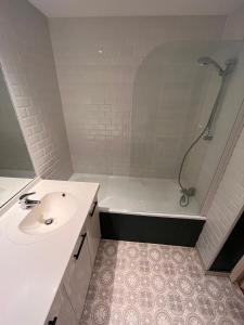 a white bathroom with a sink and a shower at Appartement T3 Cosy Tête d'Or in Villeurbanne