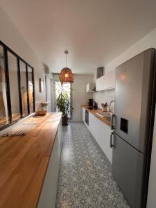 a kitchen with white cabinets and a wooden floor at Appartement T3 Cosy Tête d'Or in Villeurbanne