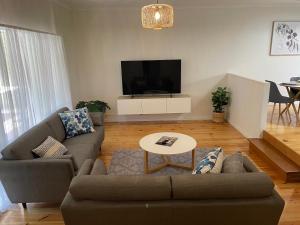 a living room with a couch and a tv at Homburg Haven in Tanunda