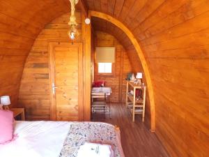 ein Schlafzimmer mit einem Bett in einer Holzhütte in der Unterkunft Casa da Avó Miquinhas in Paços de Ferreira