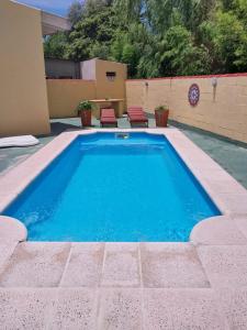 a swimming pool with blue water in a backyard at La Casona- BV Hoteles in La Falda