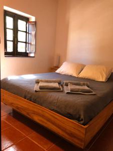 1 dormitorio con 1 cama grande y 2 almohadas en O Casal das Loureiras, en Moita dos Ferreiros