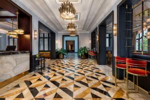 a lobby with a checkered floor and red chairs at LUME Boutique Hotel, Autograph Collection in Frankfurt/Main