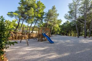 a playground with a blue slide and a swing at Villa Sun Garden in Bol