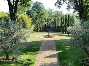 un jardin avec une statue au milieu d'un parc dans l'établissement Château Rieutort Gîtes, à Saint-Pargoire