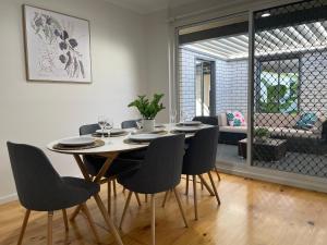 a dining table and chairs in a living room at Homburg Haven in Tanunda