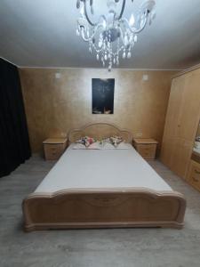 um quarto com uma cama grande e um lustre em Christine em Târgu Jiu