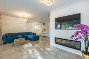 a living room with a blue couch and a fireplace at Villa Sun Garden in Bol