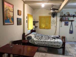 a bedroom with a bed and a table in it at Birds Nest Studio Apartment in Istmito