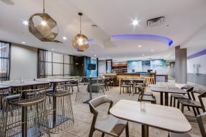 un restaurante con mesas y sillas y un bar en SpringHill Suites by Marriott Enid, en Enid