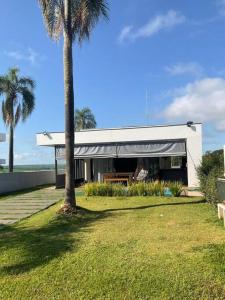 uma casa com uma palmeira num quintal em Aconchegante casa na represa. em Itaí