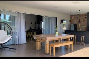 a living room with a wooden table and a couch at Aconchegante casa na represa. in Itaí