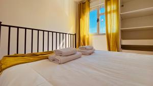 a bed with three towels on top of it at Click&Guest - Alisios House in Las Palmas in Las Palmas de Gran Canaria