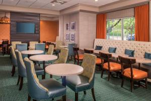 a waiting room with tables and chairs and a tv at Springhill Suites by Marriott State College in State College