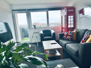 una sala de estar con una cabina de teléfono rojo en la ventana en Unique view of Anfield stadium - Charming 2 bedroom apartment in Liverpool with parking, en Liverpool