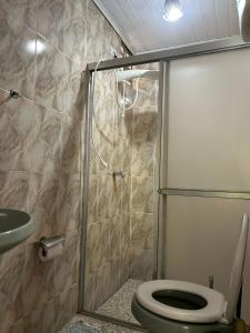 a bathroom with a shower with a toilet and a sink at Aconchegante Casa Rústica ao lado da Praia in Santa Cruz Cabrália
