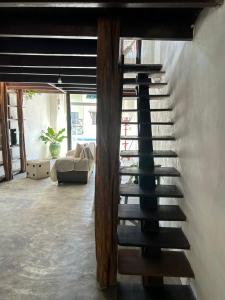 a spiral staircase in a living room with a couch at Aconchegante Casa Rústica ao lado da Praia in Santa Cruz Cabrália