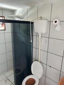 a bathroom with a toilet and a shower stall at Aconchegante Casa Rústica ao lado da Praia in Santa Cruz Cabrália