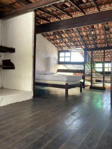 een slaapkamer met een bed in het midden van een kamer bij Aconchegante Casa Rústica ao lado da Praia in Santa Cruz Cabrália