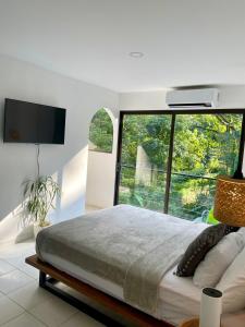 a bedroom with a large bed and a large window at Deluxe Loft 1 BDR con linda vista in Puntarenas