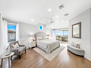 a bedroom with a bed and a couch and a chair at Beautifully Renovated Ocean Front Home In Harvey Cedars in Harvey Cedars