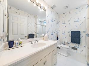 a white bathroom with a sink and a toilet at Beautifully Renovated Ocean Front Home In Harvey Cedars in Harvey Cedars