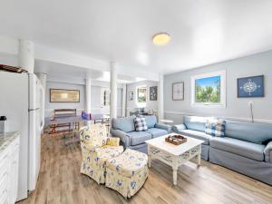 a living room with blue couches and a table at Beautifully Renovated Ocean Front Home In Harvey Cedars in Harvey Cedars